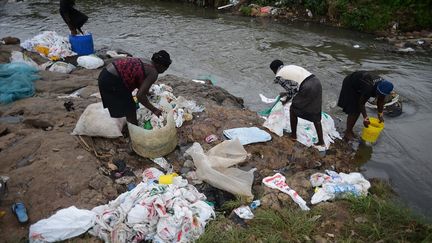 A Nairobi, au Kenya, des femmes lavent des sacs en plastique afin de les réutiliser. Depuis 2018, la vente des sacs en plastique est interdite dans le pays. (SIMON MAINA / AFP)