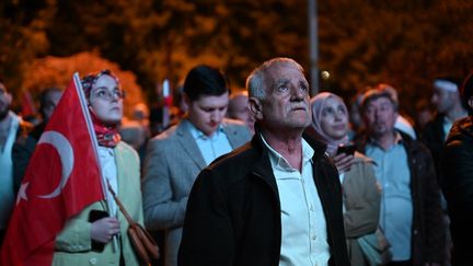 Des partisans du président sortant Recep Tayyip Erdogan attendent les résultats de l'élection présidentielle sur un écran à Istanbul (Turquie), le 14 mai 2023. (OZAN KOSE / AFP)