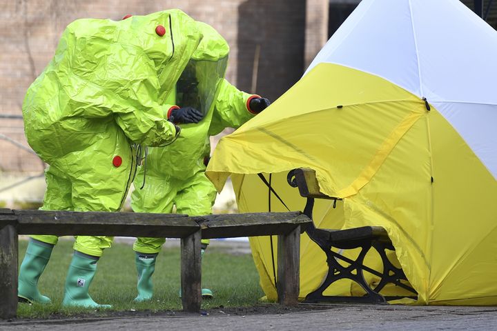 Deux membres des services d'urgence fixent une tente autour du banc où ont été retrouvés Sergueï Skripal et sa fille, le 8 mars 2018 à Salisbury (Angleterre).&nbsp; (BEN STANSALL / AFP)