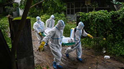 Des volontaires transportent une victime du Covid-19 à Yangon (Birmanie). Photo d'illustration. (YE AUNG THU / AFP)