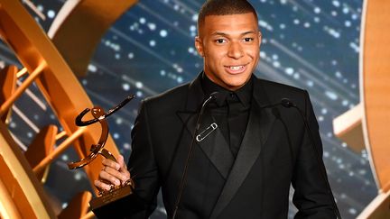 Kylian Mbappé reçoit son trophée de&nbsp;meilleur joueur et meilleur espoir du championnat de France de football pour la saison 2018-2019, le 19 mai 2019 à Paris. (FRANCK FIFE / AFP)