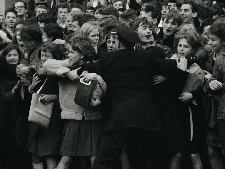 Un policier tente de contenir la foule des jeunes fans des Beatles, en février 1964, à New York (États-Unis), dans le documentaire "Beatles 64". (APPLE CORPS, LTD)