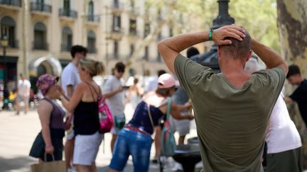 Des gens attendent pour se désaltérer devant une fontaine à Barcelone (Espagne) en pleine vague de chaleur, le 18 juillet 2023. (LORENA SOPENA / ANADOLU AGENCY / AFP)