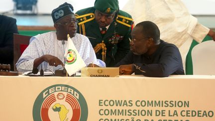 Le président de la Communauté des Etats d'Afrique de l'Ouest (Cédéao) et président du Nigeria, Bola Ahmed Tinubu, ainsi que le président de la Commission de la Cédéao, Omar Touray, photographiés à Abuja, au Nigeria, le 10 août 2023. (KOLA SULAIMON / AFP)