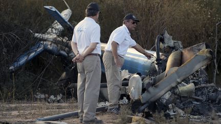 Des enqu&ecirc;teurs argentins autour de la carcasse d'un des h&eacute;licopt&egrave;res qui se sont &eacute;cras&eacute;s lors du tournage de l'&eacute;mission "Dropped" &agrave;&nbsp;Villa Castelli (Argentine), le 10 mars 2015. (JUAN MABROMATA / AFP)