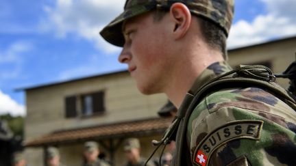 Un aspirant officier de l'armée suisse lors d'un entraînement près de Genève (Suisse), le 19 septembre 2013. (FABRICE COFFRINI / AFP)