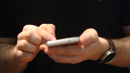 Un homme utilise un téléphone, le 11 décembre 2015 à Berlin (Allemagne). (ADAM BERRY / GETTY IMAGES EUROPE)