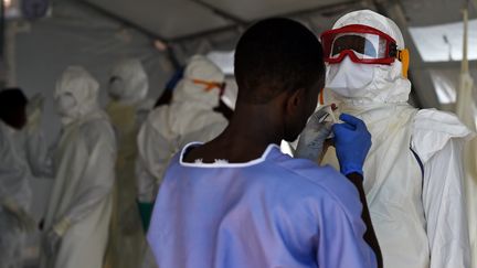 Des infirmiers s'&eacute;quipent pour soigner des patients atteints d'Ebola, le 15 novembre 2014 &agrave; Kenema (Sierra Leone). (FRANCISCO LEONG / AFP)