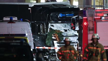 Des pompiers à proximité du camion qui a foncé sur un marché de Noël de Berlin (Allemagne), le 19 décembre 2016. (FABRIZIO BENSCH / REUTERS)