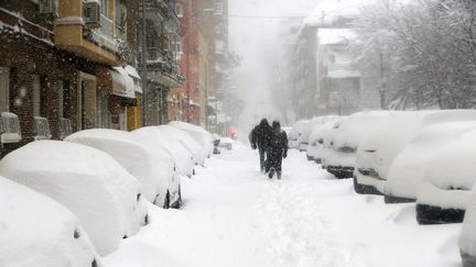 Des passants dans une rue de Madrid, en pleine tempête Filomena, le 9 janvier 2021. (SENHAN BOLELLI / ANADOLU AGENCY / AFP)