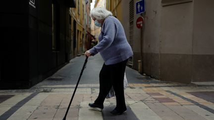 Une personne agée traverse une rue, portant son masque. Photo d'illustration. (VALERY HACHE / AFP)