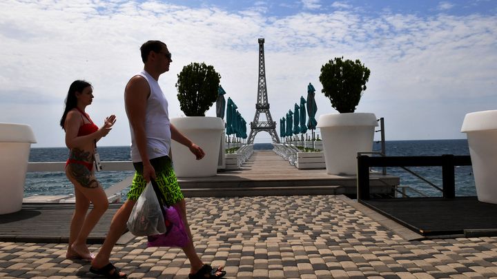 Des vacanciers devant une réplique miniature de la tour Eiffel, le 19 juin 2023 sur une plage de Yalta, en Crimée annexée par la Russie. (OLGA MALTSEVA / AFP)