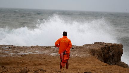 Un garde-côte sur une plage près de Cascais (Portugal) avant le passage de Leslie, le 13 octobre 2018. (RAFAEL MARCHANTE / REUTERS)