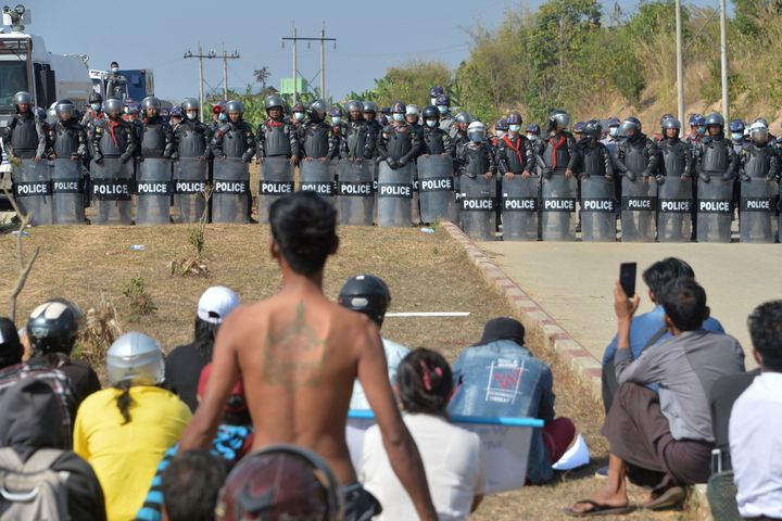 Les forces de l'ordre font face aux manifestants qui protestent contre le coup d'Etat, à Naypyidaw (Birmanie), le 15 février 2021. (STR / AFP)