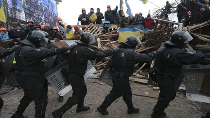 Des manifestants pro-europ&eacute;ens montent sur les barricades, le 11 d&eacute;cembre 2013, sur la place de l'Ind&eacute;pendance &agrave; Kiev (Ukraine).&nbsp; (KONSTANTIN CHERNICHKIN / REUTERS)