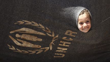 Une jeune r&eacute;fugi&eacute;e syrienne s'amuse avec la tente de sa famille dans le camp d'Al Za'atri &agrave; la fronti&egrave;re jordanienne, le 29 ao&ucirc;t 2012. (ALI JAREKJI / REUTERS)