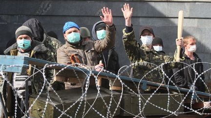 Des activistes pro-russes montent la garde devant une barricade dress&eacute;e &agrave; Donetsk, dans l'est de l'Ukraine, lundi 7 avril 2014. (ALEXANDER KHUDOTEPLY / AFP)