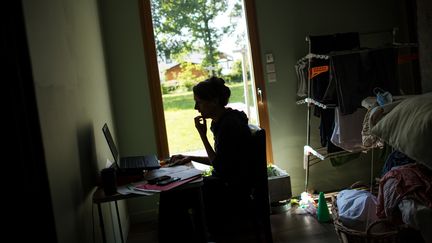 Une femme en télétravail chez elle. Photo d'illustration. (LOIC VENANCE / AFP)