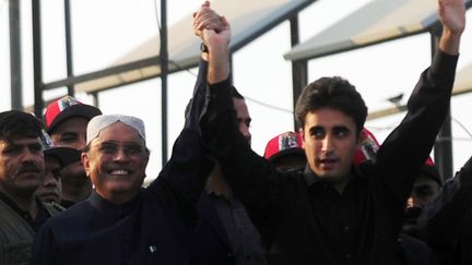 Le pr&eacute;sident du Pakistan, Asif Ali Zardari, et son fils&nbsp;Bilawal, saluent des partisans &agrave;&nbsp;Garhi Khuda Bakhsh le 27 d&eacute;cembre 2012. (RIZWAN TABASSUM / AFP)