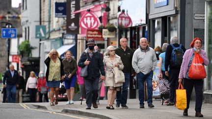 Des passants dans une rue de la ville de Kendal, dans le nord de l'Angleterre, le 21 juin 2021. (OLI SCARFF / AFP)