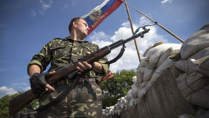 Un rebelle pro-russe monte la garde devant un checkpoint, le 24 juin 2014, &agrave; Lysychansk, dans la r&eacute;gion de Louhansk (Ukraine). (SHAMIL ZHUMATOV / REUTERS)