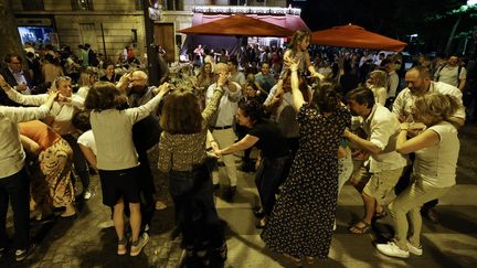 Des parisiens dansent dans la rue à l'occasion de la 40e édition de la Fête de la musique, le 21 juin 2022. (LUDOVIC MARIN / AFP)