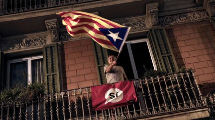 Un homme agite un drapeau catalan en faveur de l'indépendance, le 1er octobre 2017 à Barcelone. (PAU BARRENA / AFP)