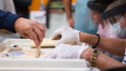 Une personne vote lors du second tour des élections municipales françaises à Marseille, le 28 juin 2020. Photo d'illustration. (CLEMENT MAHOUDEAU / AFP)