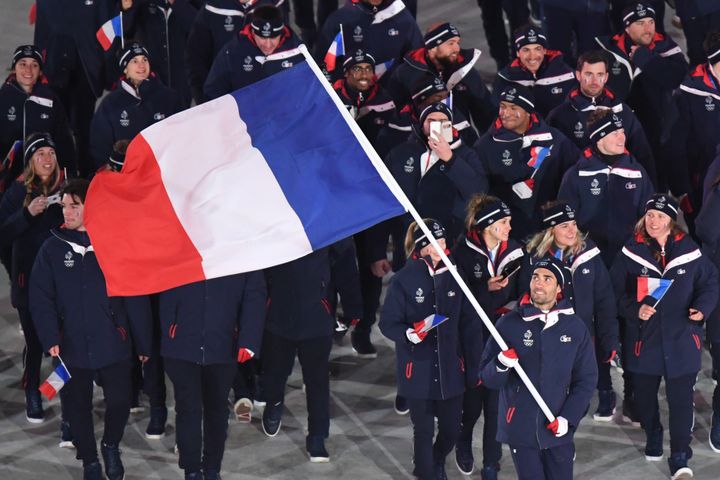 Martin Fourcade défile avec le drapeau français (FRANCK FIFE / POOL)