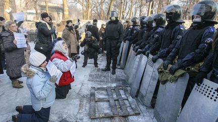 Des femmes s'agenouillent devant les forces de l'ordre, le 24 janvier 2014, &agrave; Kiev (Ukraine).&nbsp; (GLEB GARANICH / REUTERS)