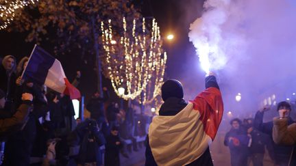 Un fan de l'équipe de France de football célèbre la victoire des Bleus en demi-finale de la Coupe du monde, sur les Champs-Elysées, à Paris, le 14 décembre 2022. (THIBAUD MORITZ / AFP)