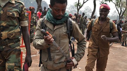 Un membre des forces arm&eacute;es centrafricaines (FACA) range son arme apr&egrave;s le lynchage d'un homme soup&ccedil;onn&eacute; d'entre un ancien rebelle de la Seleka, le 5 f&eacute;vrier 2014 &agrave; Bangui (Centrafrique). (ISSOUF SANOGO / AFP)