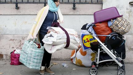 A Lyon, une&nbsp;Rom quitte le camp de fortune install&eacute; pr&egrave;s de la gare de Perrache. (PASCAL FAYOLLE/SIPA)