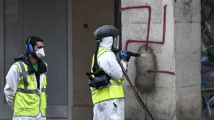 Un agent municipal nettoie une croix gammée peinte sur une colonne, rue de Rivoli, à Paris, le 11 octobre 2020. (STEPHANE DE SAKUTIN / AFP)