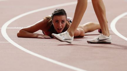 L'athlète tchèque Diana Mezulianikova s'effondre au sol pendant son 800 m. (ALEKSANDRA SZMIGIEL / REUTERS)