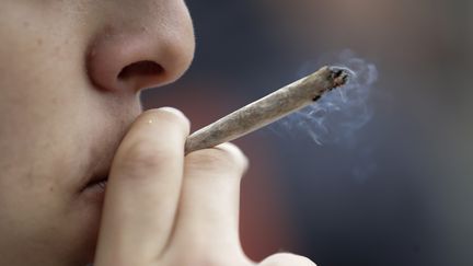 Un homme fume du cannabis, à Paris, le 12 mai 2018. (THOMAS SAMSON / AFP)