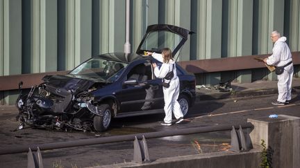 La police scientifique examine la carcasse d'une voiture, le 19 août 2020, après une série d'accidents provoqués délibérément la veille par un homme sur une autoroute périphérique de Berlin (Allemagne). (ODD ANDERSEN / AFP)