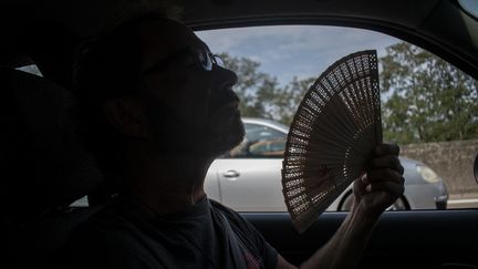 Un automobiliste dans sa voiture, en période de forte chaleur, le 25 juillet 2022 (MAGALI COHEN / HANS LUCAS)