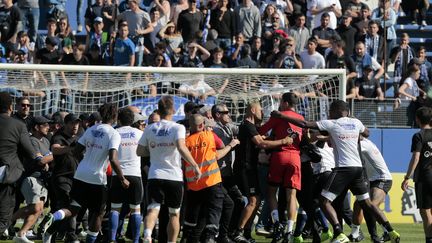 Des supporters corses envahissent le terrain de foot pendant le match entre Bastia et Lyon, le 16 avril 2017. (PASCAL POCHARD-CASABIANCA / AFP)