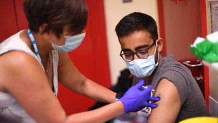 Un étudiant reçoit une dose du vaccin&nbsp;Pfizer/BioNTech contre le Covid-19 à Londres (Angleterre) le 5 juin 2021. (DANIEL LEAL-OLIVAS / AFP)