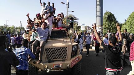 Des manifestants soudanais font le V de la victoire sur le capot d'un véhicule militaire le 7 avril 2019 à Khartoum. (AFP)