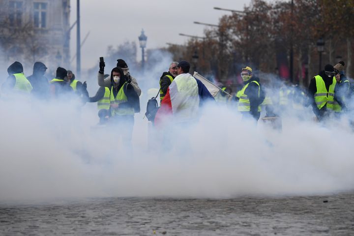 Des manifestants dans un nuage de gaz lacrymogène, le 1er décembre 2018, à Paris. (ALAIN JOCARD / AFP)