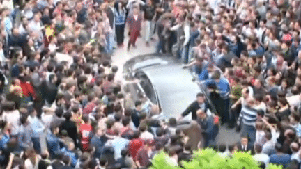 Des manifestants s'en prennent &agrave; la voiture o&ugrave; se trouve le Premier ministre Erdogan, mercredi 14 mai &agrave; Soma (Turquie). (AP / FRANCETV INFO)