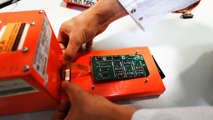 An investigator from the French Bureau of Investigation and Analysis for Civil Aviation Safety (BEA) works on a flight recorder on September 7, 2018 in Le Bourget, in the Paris region. (ALAIN JOCARD / AFP)