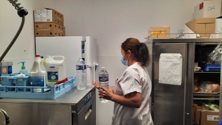 Marina Ferrand, aide-soignante au CHU de Nîmes (Gard), se prépare à apporter de l'eau à des patients qui attendent aux urgences un jour de canicule, le 19 juillet 2023. (LOUIS BOY / FRANCEINFO)