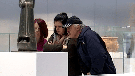 Des visiteurs devant  une statue de l'exposition "Les Etrusques et la Méditerranée"
