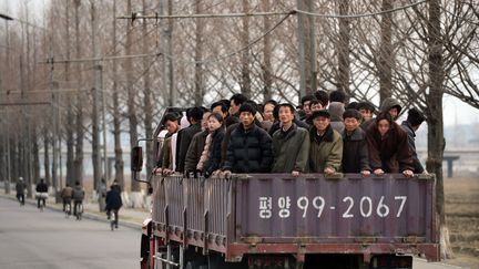 Sur les routes, des voyageurs se rendent au travail &agrave; l'arri&egrave;re d'une camionnette. (PEDRO UGARTE / AFP)