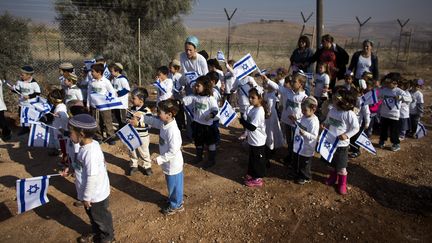 Des enfants isra&eacute;liens avec leurs drapeaux au sein de la colonie de Gitit, dans la vall&eacute;e du Jourdain, le 2 janvier 2014. (RONEN ZVULUN / REUTERS)