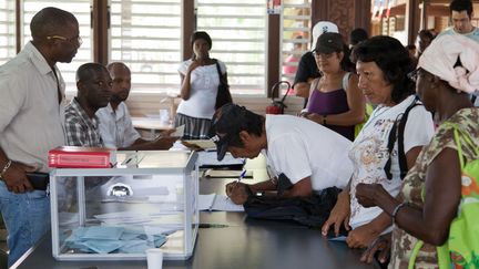 Des &eacute;lecteurs votent dans un bureau de Guyanne, le 22 avril 2012. (JODY AMIET / AFP)