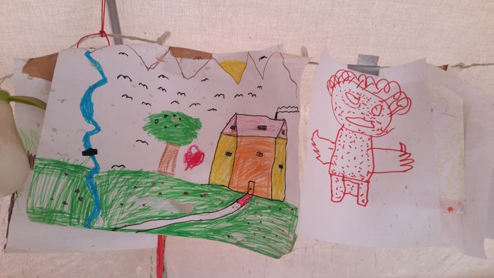 Des dessins d'enfants dans la tente de l'ONG Save The Children, à Idomeni (Grèce), le 16 mars 2016. (LOUIS SAN / FRANCETV INFO)